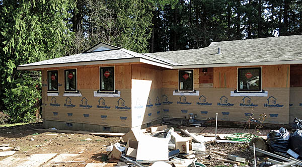 A view from the driveway of the hall bathroom window and part of the addition with half of the building paper installed.