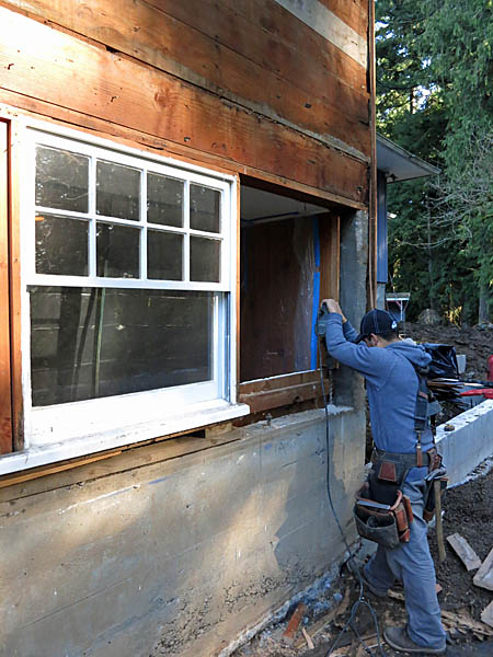 The right hand window was removed and holes were drilled into the concrete foundation wall. Threaded rods were inserted into these holes for structural hold-downs. Since so much of the wall was becoming glass, we needed to increase the lateral stability of the wall. This was accomplished with the hold-downs and a plywood shear panel.